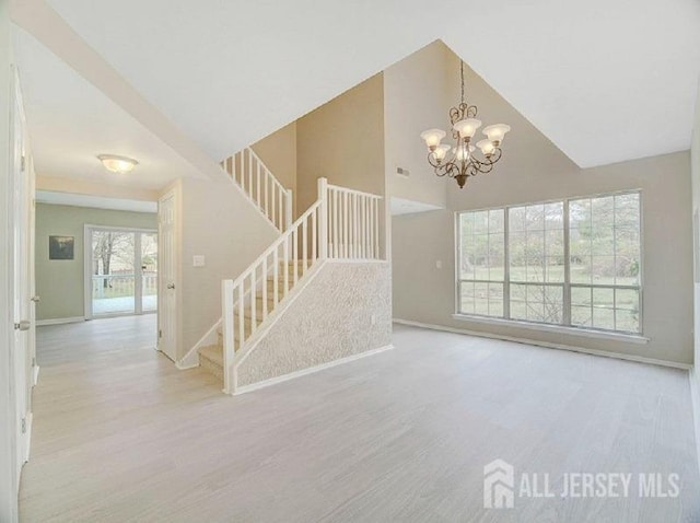 308 Pewter Ct, Old Bridge, NJ 08857 - unfurnished living room with stairs, wood finished floors, baseboards, a chandelier, and high vaulted ceiling