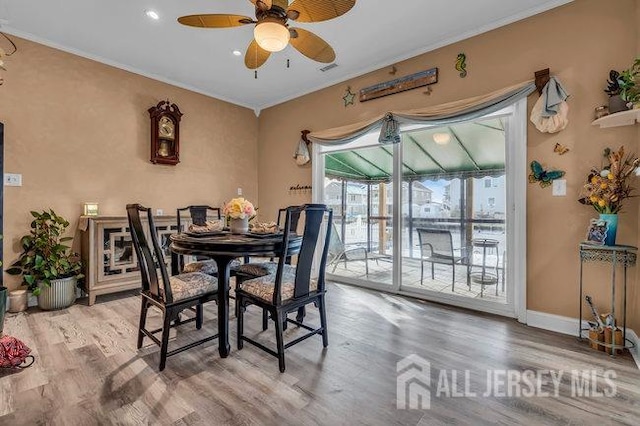 dining space with ornamental molding, ceiling fan, and light hardwood / wood-style flooring