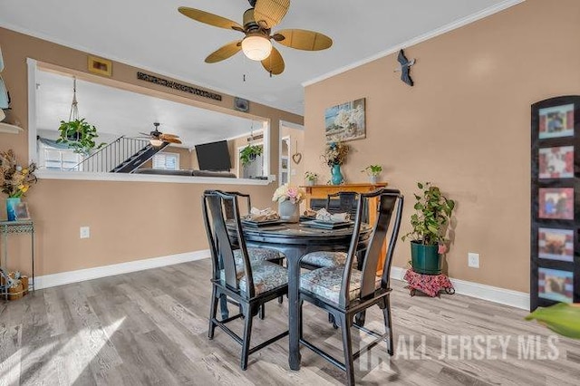 dining room featuring ceiling fan, ornamental molding, and wood-type flooring