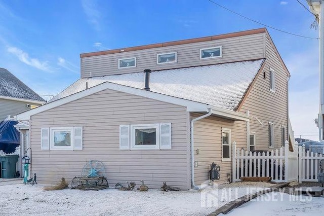 view of snow covered rear of property