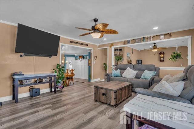 living room featuring ornamental molding, hardwood / wood-style flooring, and ceiling fan