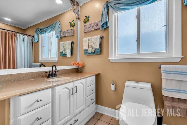 bathroom with tile patterned floors, a wealth of natural light, toilet, and vanity