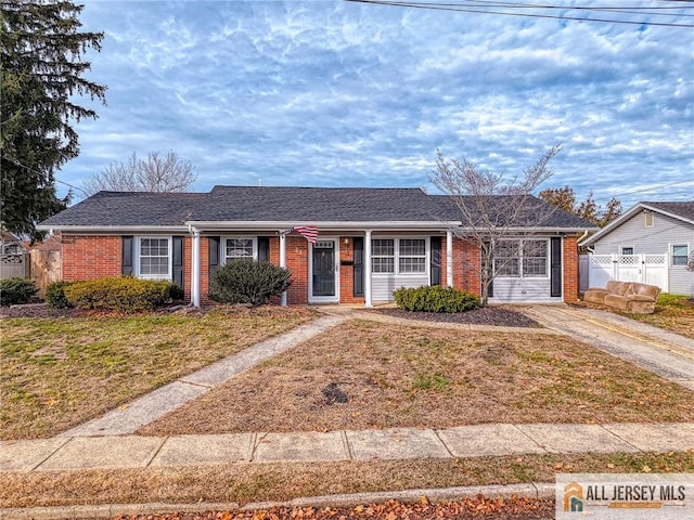 single story home with a front yard, fence, and brick siding