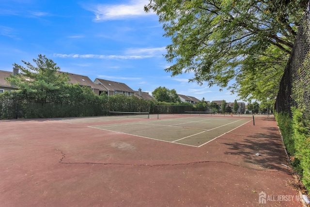 view of tennis court featuring fence