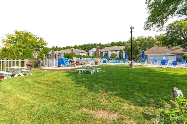 view of yard featuring a community pool, fence, and a patio