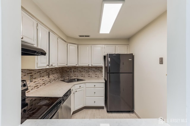 kitchen with appliances with stainless steel finishes, white cabinetry, tasteful backsplash, and sink