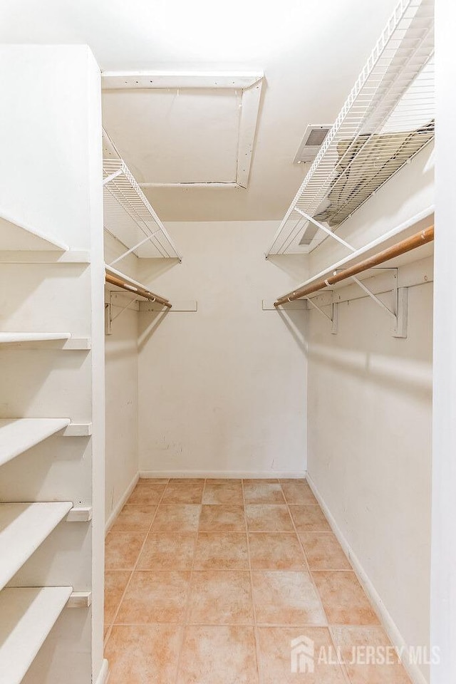 spacious closet with tile patterned floors