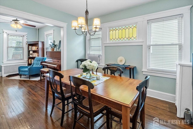dining room featuring hardwood / wood-style floors, ceiling fan, a chandelier, baseboards, and radiator