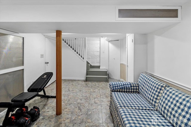 finished below grade area with stairs, stone finish flooring, and baseboards