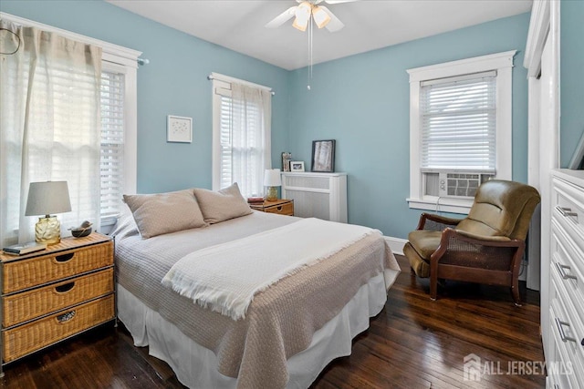 bedroom with dark wood-style floors, ceiling fan, and baseboards