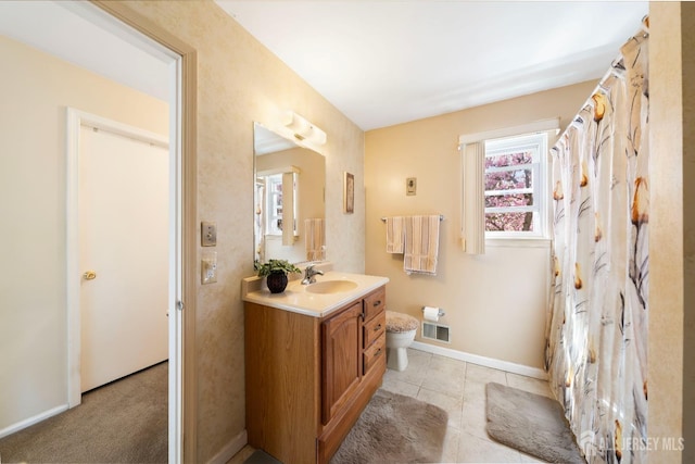 bathroom with toilet, vanity, visible vents, tile patterned flooring, and baseboards