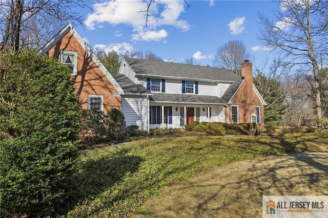 traditional-style home with a chimney and a front yard