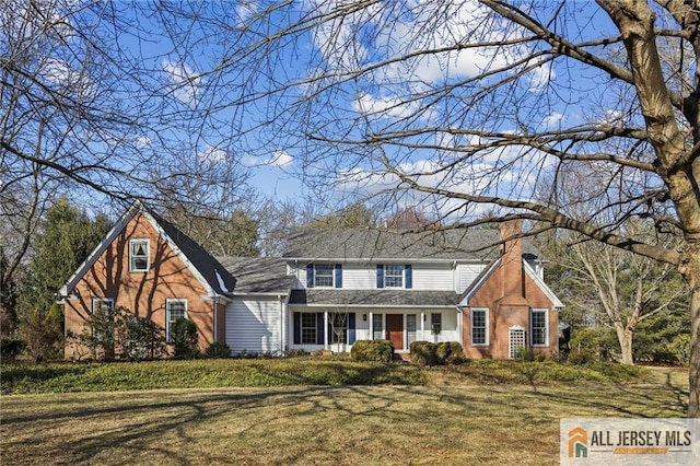 view of front of house with a chimney and a front lawn