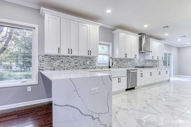 kitchen featuring a wealth of natural light, white cabinetry, wall chimney exhaust hood, light stone countertops, and crown molding