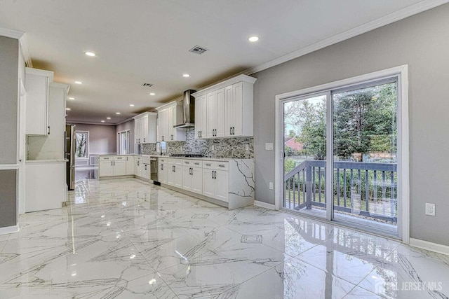 kitchen with white cabinets, wall chimney range hood, crown molding, and stainless steel gas cooktop