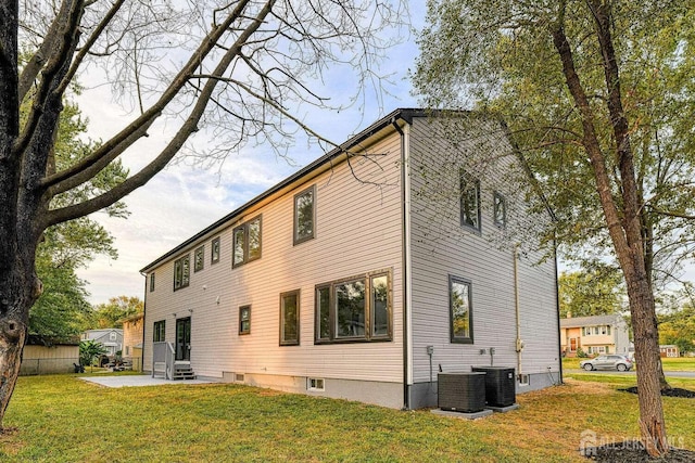 rear view of property with a yard, central AC, and a patio area