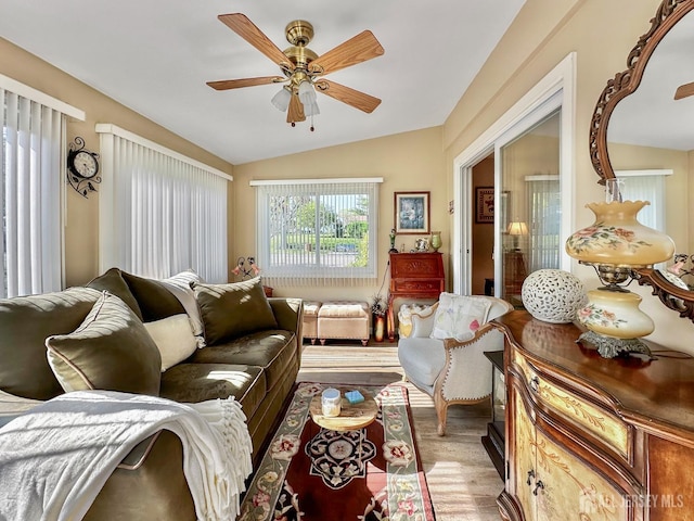 living room with a ceiling fan, light wood finished floors, and vaulted ceiling