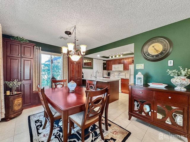 dining space featuring a chandelier, light tile patterned floors, visible vents, and a textured ceiling