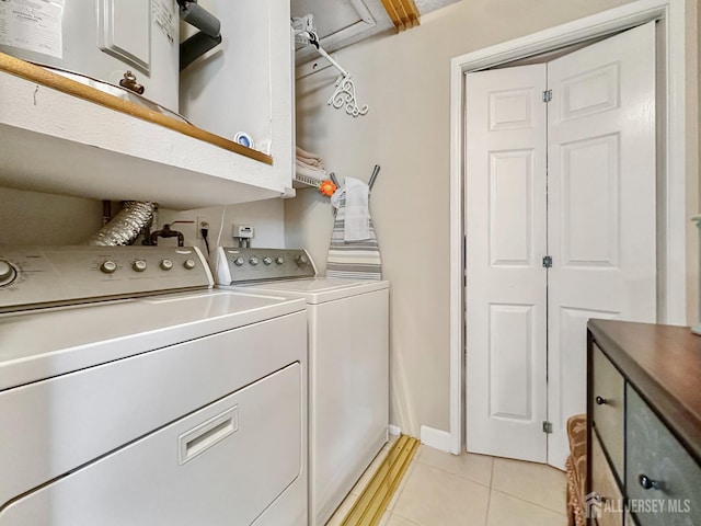 clothes washing area with laundry area, light tile patterned flooring, and washer and dryer