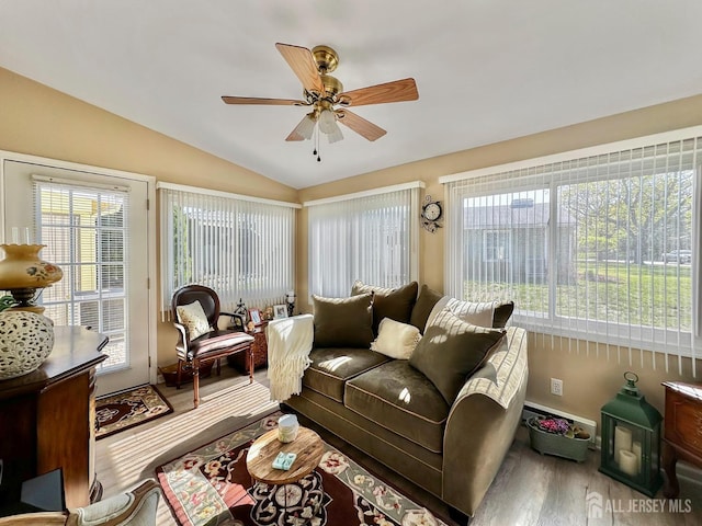 living area with vaulted ceiling, ceiling fan, baseboards, and wood finished floors