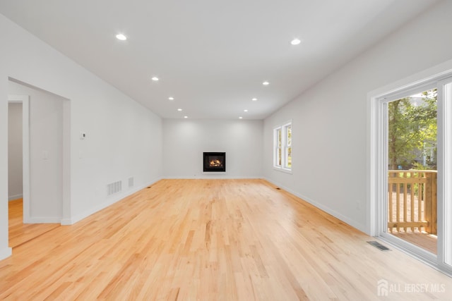 709 Plainfield Ave, Piscataway, NJ 08854 - unfurnished living room featuring plenty of natural light, light wood-type flooring, recessed lighting, and a glass covered fireplace