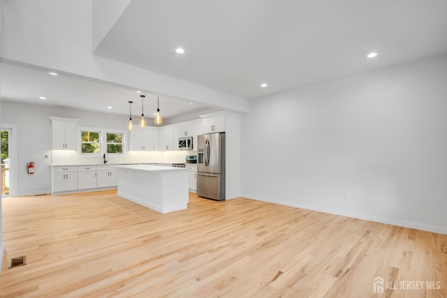 709 Plainfield Ave, Piscataway, NJ 08854 - kitchen featuring stainless steel appliances, light wood finished floors, healthy amount of natural light, white cabinetry, and recessed lighting