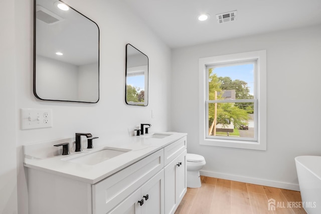 709 Plainfield Ave, Piscataway, NJ 08854 - bathroom featuring double vanity, a freestanding bath, wood finished floors, and recessed lighting