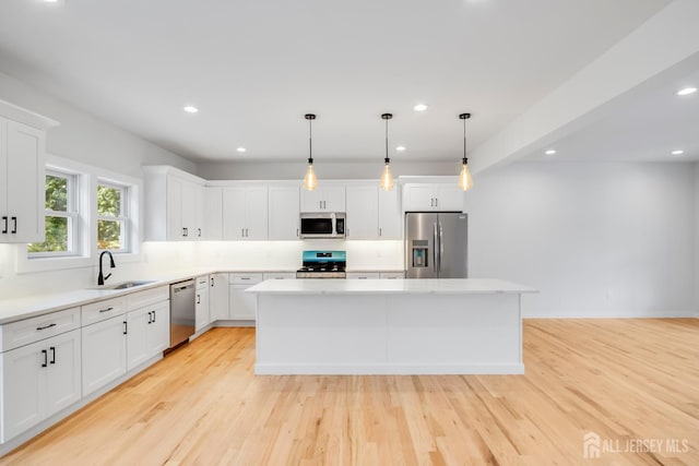 709 Plainfield Ave, Piscataway, NJ 08854 - kitchen with stainless steel appliances, a center island, white cabinetry, recessed lighting, and light wood-type flooring