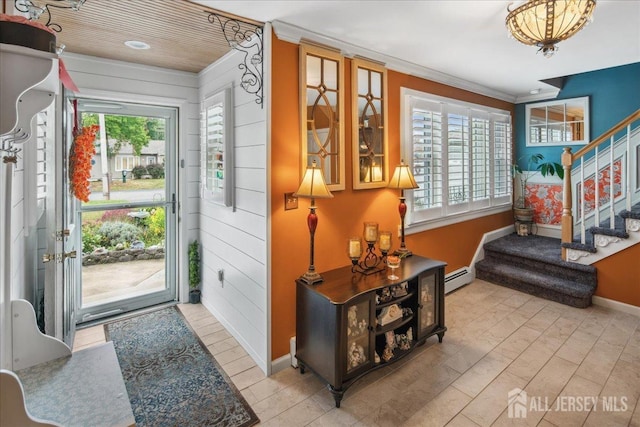 entrance foyer featuring plenty of natural light, crown molding, wooden walls, and a baseboard radiator