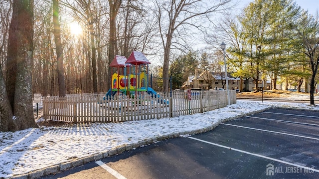 snow covered playground with fence and playground community