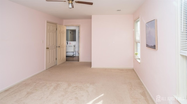 unfurnished room with carpet floors, ceiling fan, visible vents, and baseboards