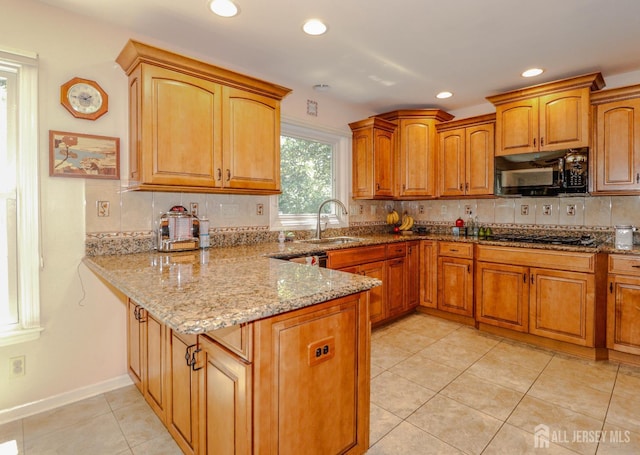 89 King St, Edison, NJ 08820 - kitchen featuring black microwave, a peninsula, light stone counters, light tile patterned floors, and backsplash