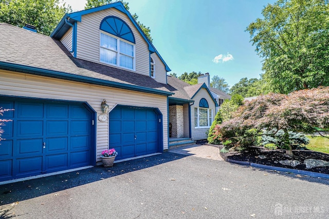 89 King St, Edison, NJ 08820 - view of front of property with roof with shingles, asphalt driveway, and a chimney