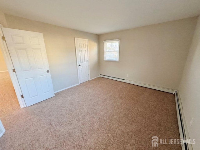 unfurnished bedroom featuring baseboard heating, a closet, and carpet flooring