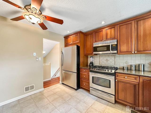 12 Dana Estates Dr, Old Bridge, NJ 08859 - kitchen with stainless steel appliances, brown cabinets, ceiling fan, backsplash, and a textured ceiling
