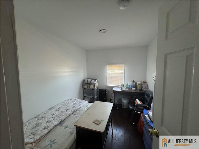 bedroom with dark wood-style flooring