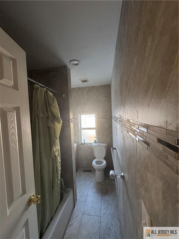 full bathroom featuring visible vents, tile patterned flooring, toilet, and shower / tub combo with curtain