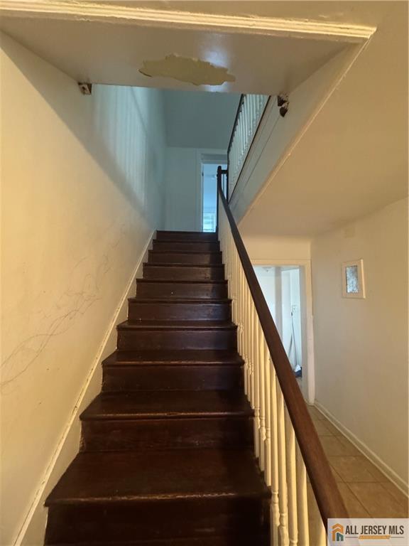 stairs featuring tile patterned floors and baseboards