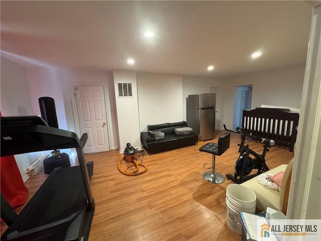 living area with recessed lighting, visible vents, and light wood-style floors