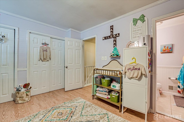 325 Mcdowell Dr, East Brunswick, NJ 08816 - bedroom featuring ornamental molding, wood finished floors, wainscoting, and connected bathroom