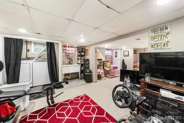 exercise area featuring a drop ceiling and separate washer and dryer