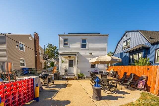 back of house featuring entry steps, a fenced backyard, and a patio