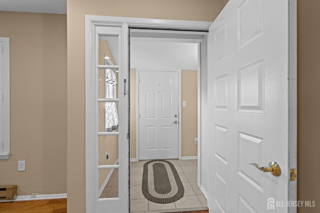 entryway featuring baseboards and light tile patterned floors