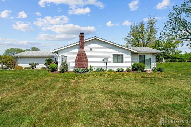 view of side of home with a lawn and a chimney