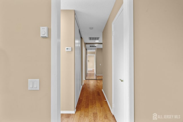 hallway featuring wood finished floors and baseboards