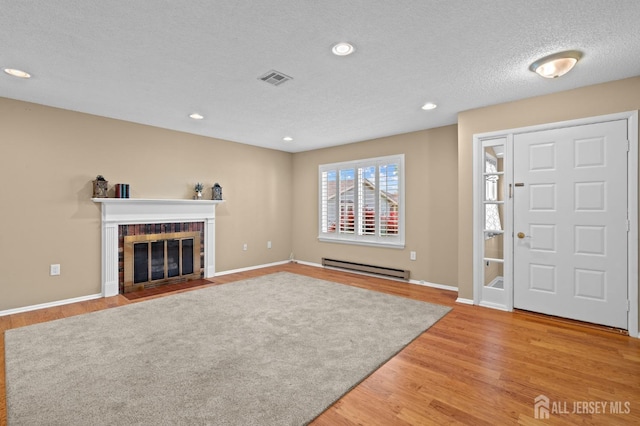 entryway with baseboard heating, a fireplace, light wood-style floors, baseboards, and recessed lighting