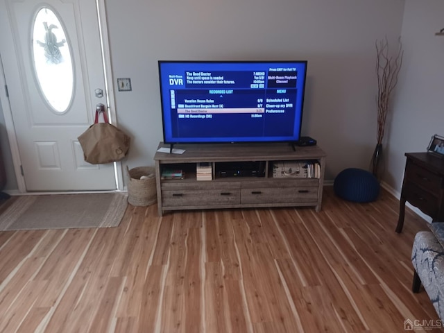 living area featuring baseboards and wood finished floors