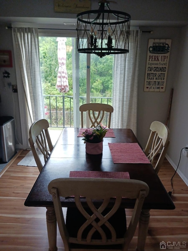 dining space with baseboards and wood finished floors