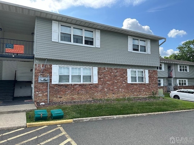 view of front of home with uncovered parking and brick siding