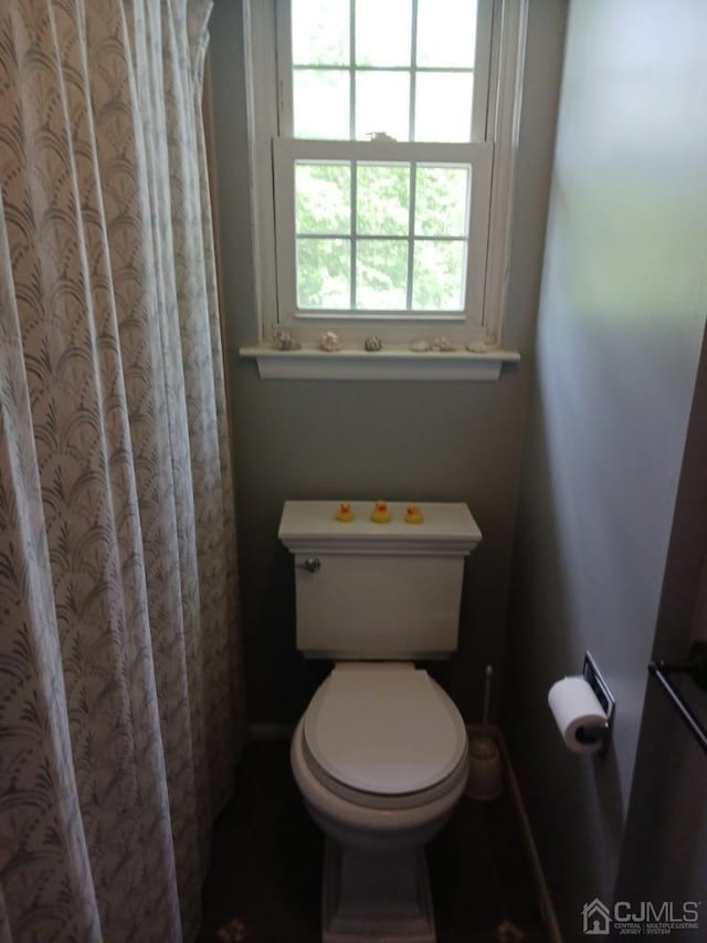 bathroom featuring toilet and a shower with curtain